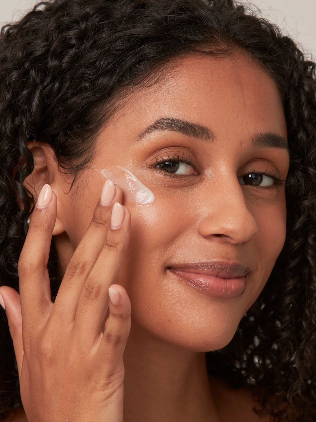 A woman applying AMPERNA® face lotion, supporting the skin barrier with gentle, postbiotic skincare